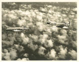 Printed black and white photograph of a Skyraider refueling a Skyray midflight