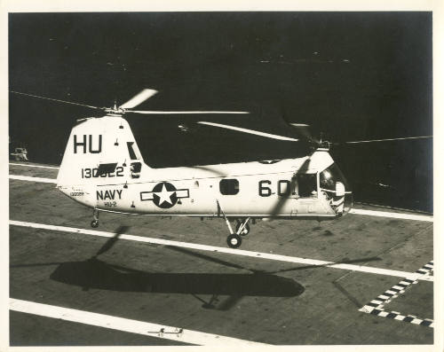 Printed black and white photograph of a HUP-2 Retriever above Intrepid's flight deck
