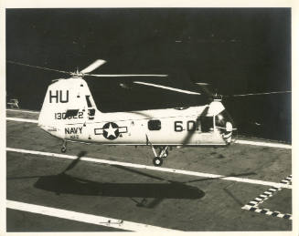 Printed black and white photograph of a HUP-2 Retriever above Intrepid's flight deck