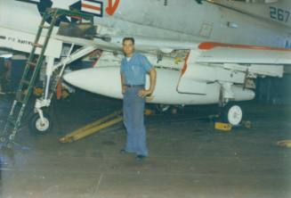 Color photograph of Agustin Ramos standing next to a Douglas A-4 Skyhawk