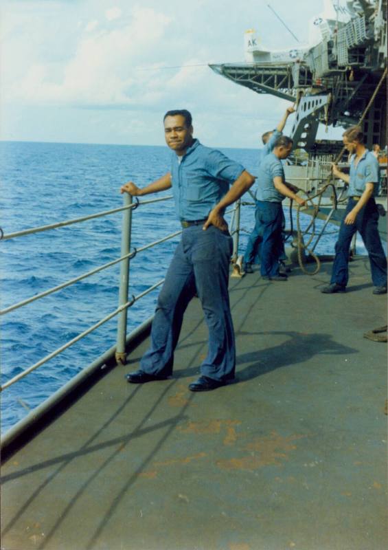 Color photograph of Agustin Ramos standing on a sponson with the ocean in the background