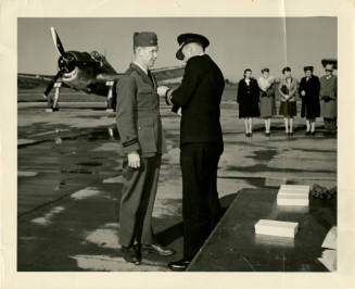 Printed black and white photograph of Forrest Masters being given the Air Medal