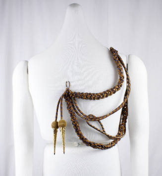 U.S. Navy dress aiguillette on a mannequin torso with braided gold cord with blue stripes and t…