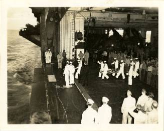 Printed black and white photograph of a burial at sea on USS Intrepid