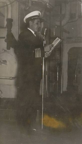 Black and white photograph of Capt. Henry G. Sanchez speaking into a microphone