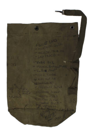 Olive drab seabag with black handwritten list of ports of call visited during USS Intrepid depl…
