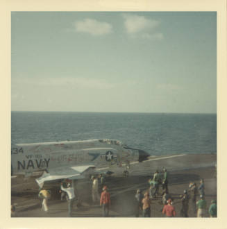 Color photograph of a graffitied F-4 Phantom about to launch off Intrepid's flight deck