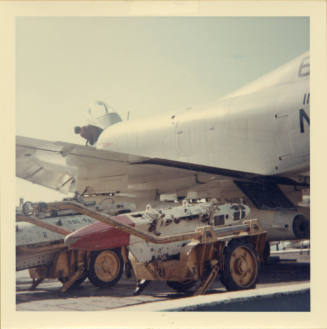 Color photograph of an Intrepid crewmember modifying a Skyhawk