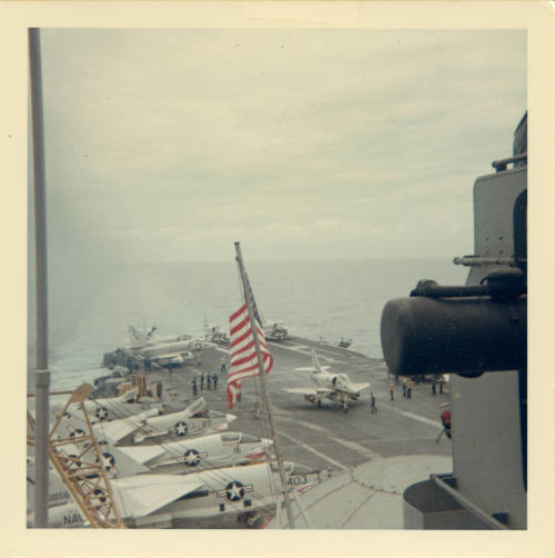 Color photograph of an A-4 Skyhawk and other aircraft on Intrepid's flight deck