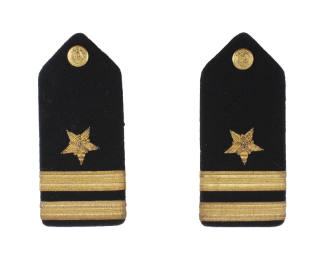 Pair of U.S. Navy blue shoulder boards, each with gold button, five pointed star and two stripe…