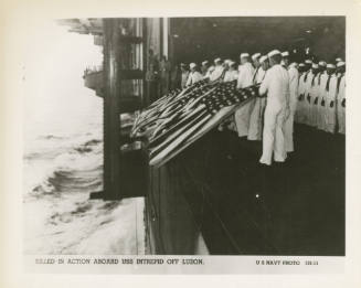 Printed black and white photograph of a burial at sea for the men killed in Gun Tub 10 on USS I…