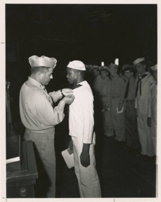 Black and white photograph of Captain Joseph Bolger awarding the Navy Cross to Eli Benjamin