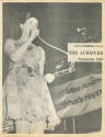 Black and white photograph of a woman talking into a microphone on the cover of the USS Intrepi…