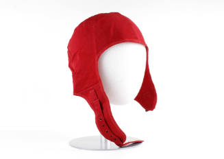 Left side view of red canvas flight deck cap with chin strap and buckle on mannequin head form