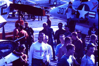 Digital color photograph of Intrepid crewmembers on the flight deck looking towards the camera