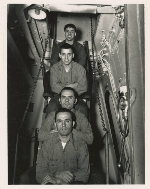 Printed black and white photograph of two sets of twins from USS Intrepid's crew seated on a la…