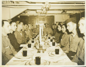Printed black and white photograph of a Passover Seder aboard USS Intrepid with crew members si…
