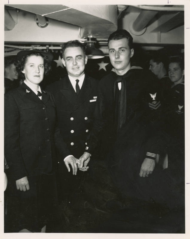 Printed black and white photograph of two men and a woman at USS Intrepid's first wedding