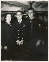 Printed black and white photograph of two men and a woman at USS Intrepid's first wedding