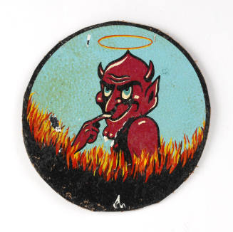 Round insignia patch depicting red devil with mischievous face on blue background and flames