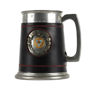 Pewter mug with black leather band and raised insignia design in the center