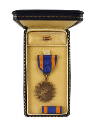 Air Medal in open presentation box with ribbon bar and lapel pin inside
