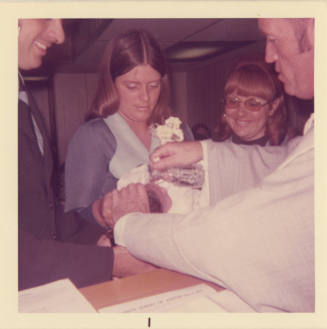 Printed color photograph of a baby being baptized on board Intrepid