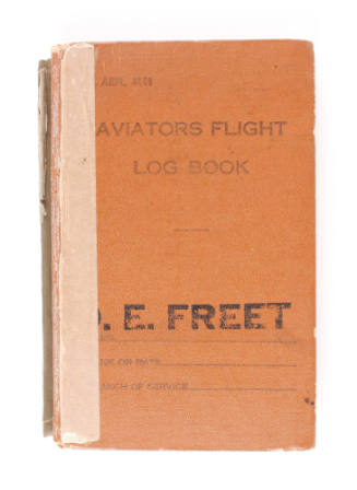 Orange hardcover book titled "Aviators Flight Log Book” with "D.E. Freet" stamped in black ink