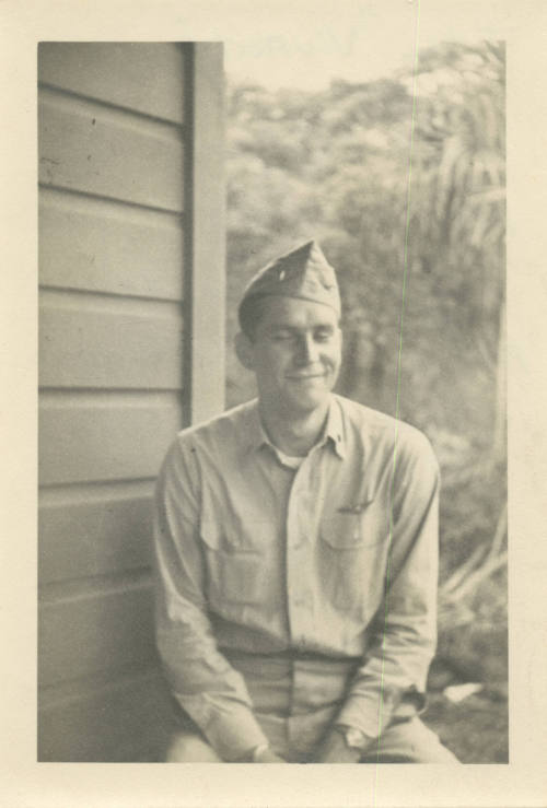 Printed black and white photograph of Donald Freet in a khaki uniform sitting outside