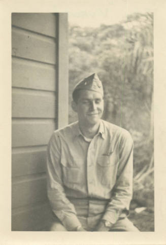 Printed black and white photograph of Donald Freet in a khaki uniform sitting outside
