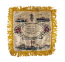 Front of square silk pillowcase with yellow fringe, poem in center and image of ships at sea on…