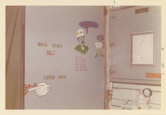 Color photograph of the door to the brig on USS Intrepid with sailor art and graffiti