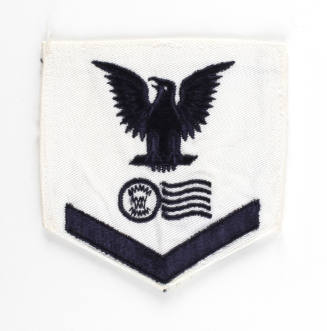 White U.S. Navy uniform patch with dark blue eagle, chevrons and image of a postmark and cancel…