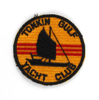 Yellow circular embroidered patch with image of black junk ship in front of three red stripes, …