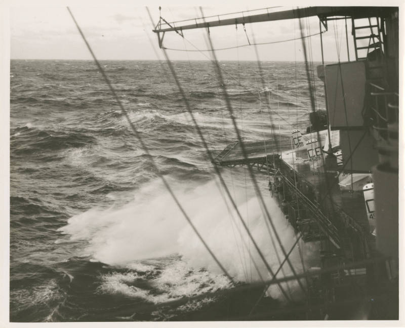 Black and white photograph of the starboard side of the aircraft carrier USS Intrepid with wave…