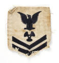 White U.S. Navy uniform patch with dark blue eagle, chevrons and image of a three-bladed propel…