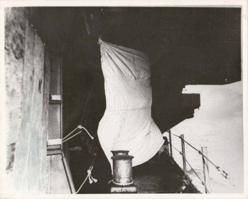 Black and white photograph of a makeshift sail on the exterior of USS Intrepid's fo'c'sle