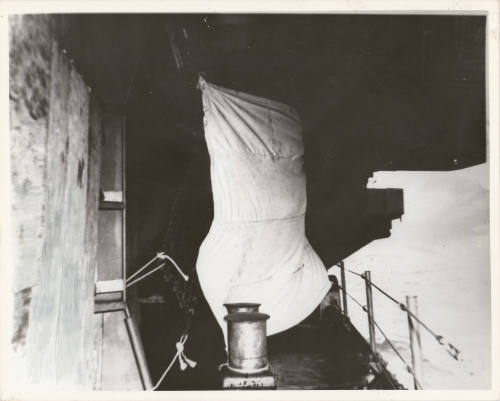 Black and white photograph of a makeshift sail on the exterior of USS Intrepid's fo'c'sle