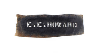 Brown stencil with black paint over cut-out letters spelling "E.E. Howard"